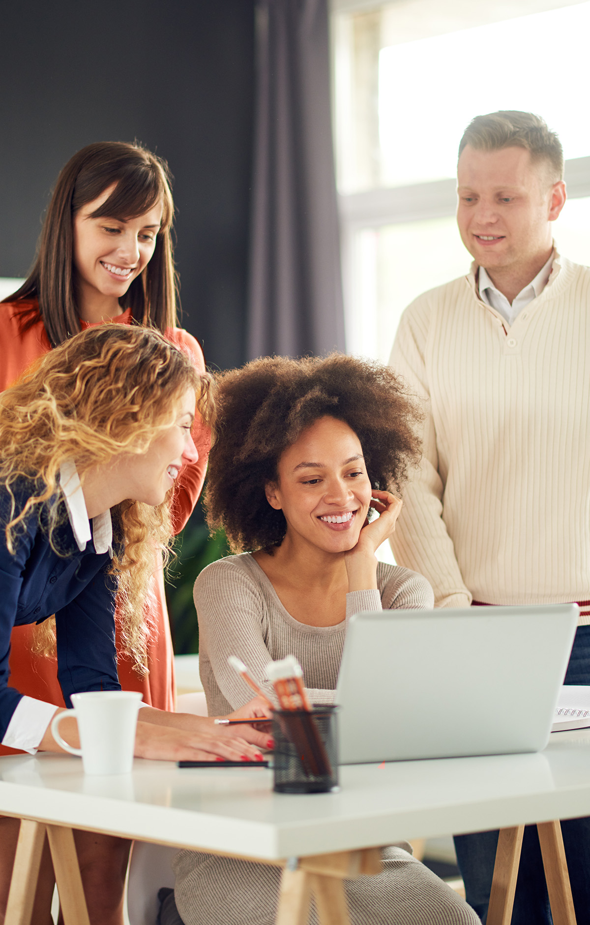 A group of professionals looking at a laptop